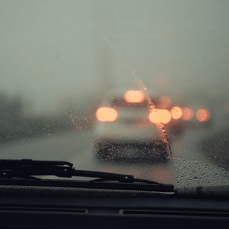 view out a windshield of a car in the rain