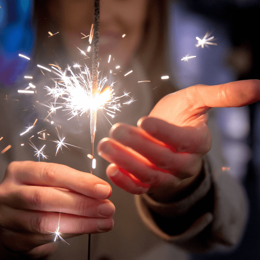 Woman in the background holding a lit sparkler