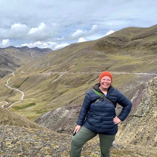 Woman standing at the top of a mountain