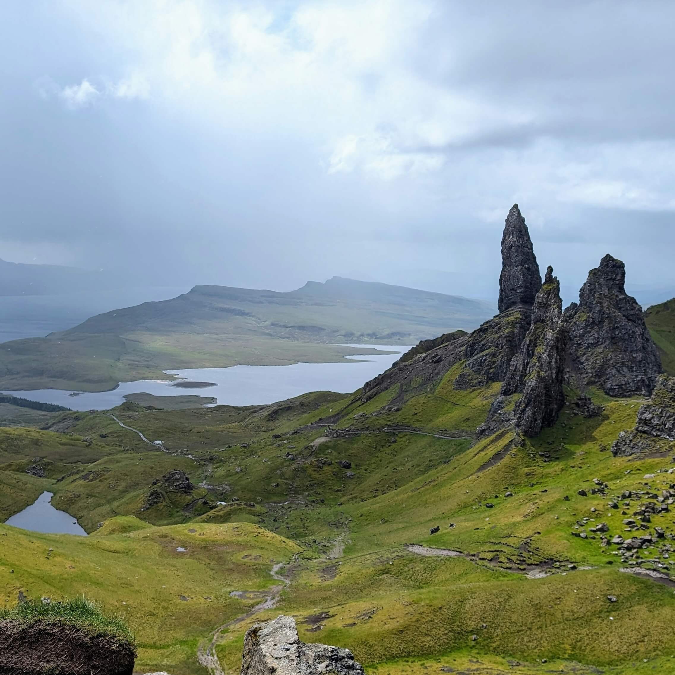 Old Man of Storr, a rocky mountain in norther Scotland, surrounded by rolling hills and ocean