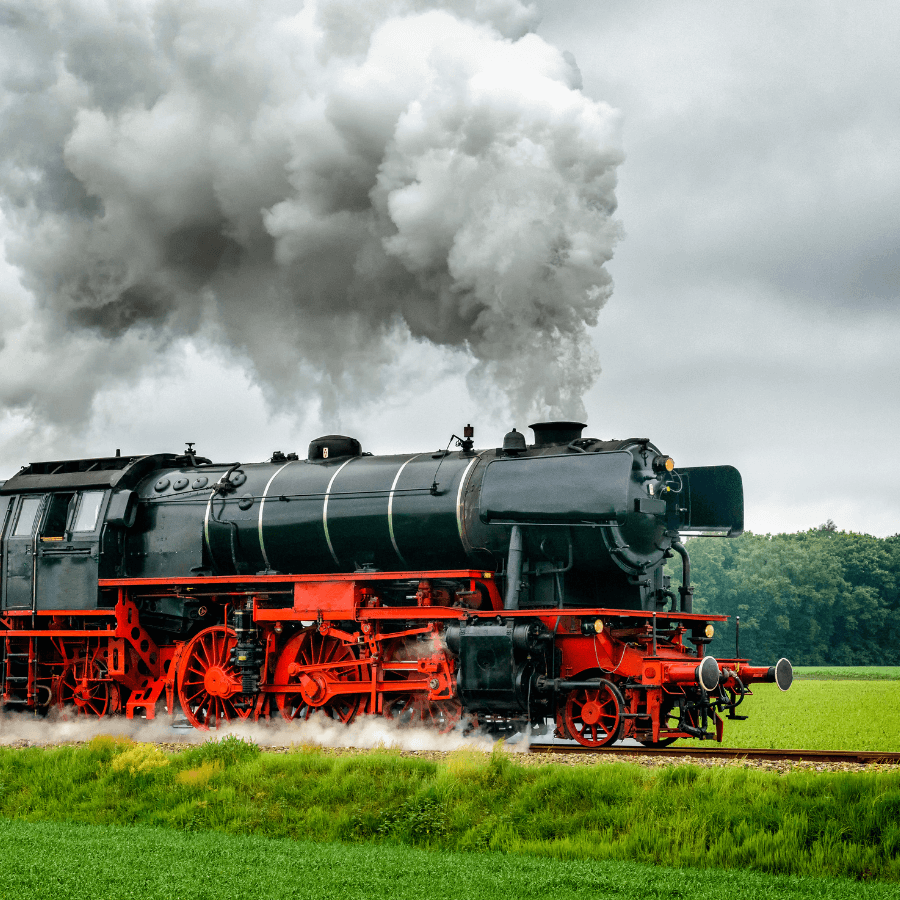 a black and red train engine, blowing steam into the air as it drives through the countryside