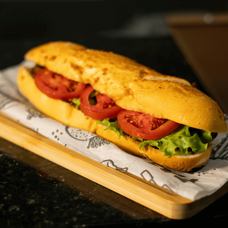 a sub sandwich on a six inch white bun, with lettuce and tomato
